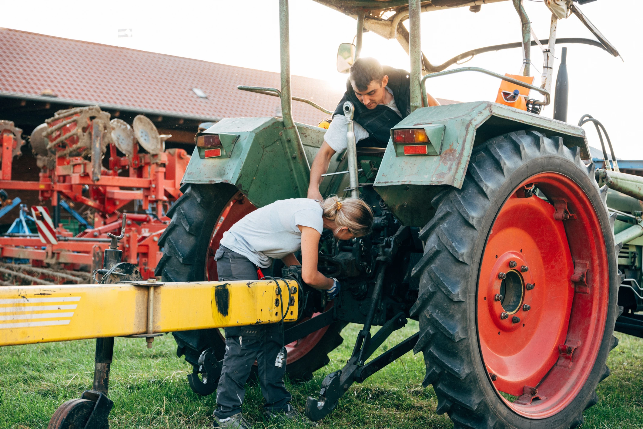 young_farmers_fixing_tractor_agriculture_cooperative